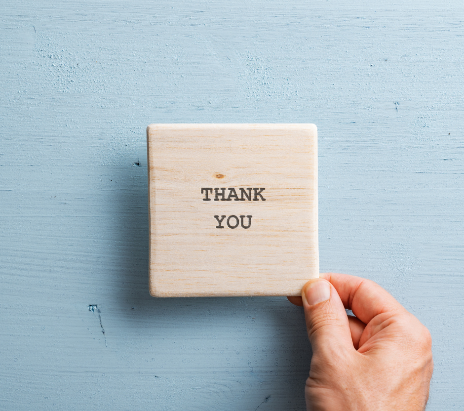 hand holding a sign that reads thank you.